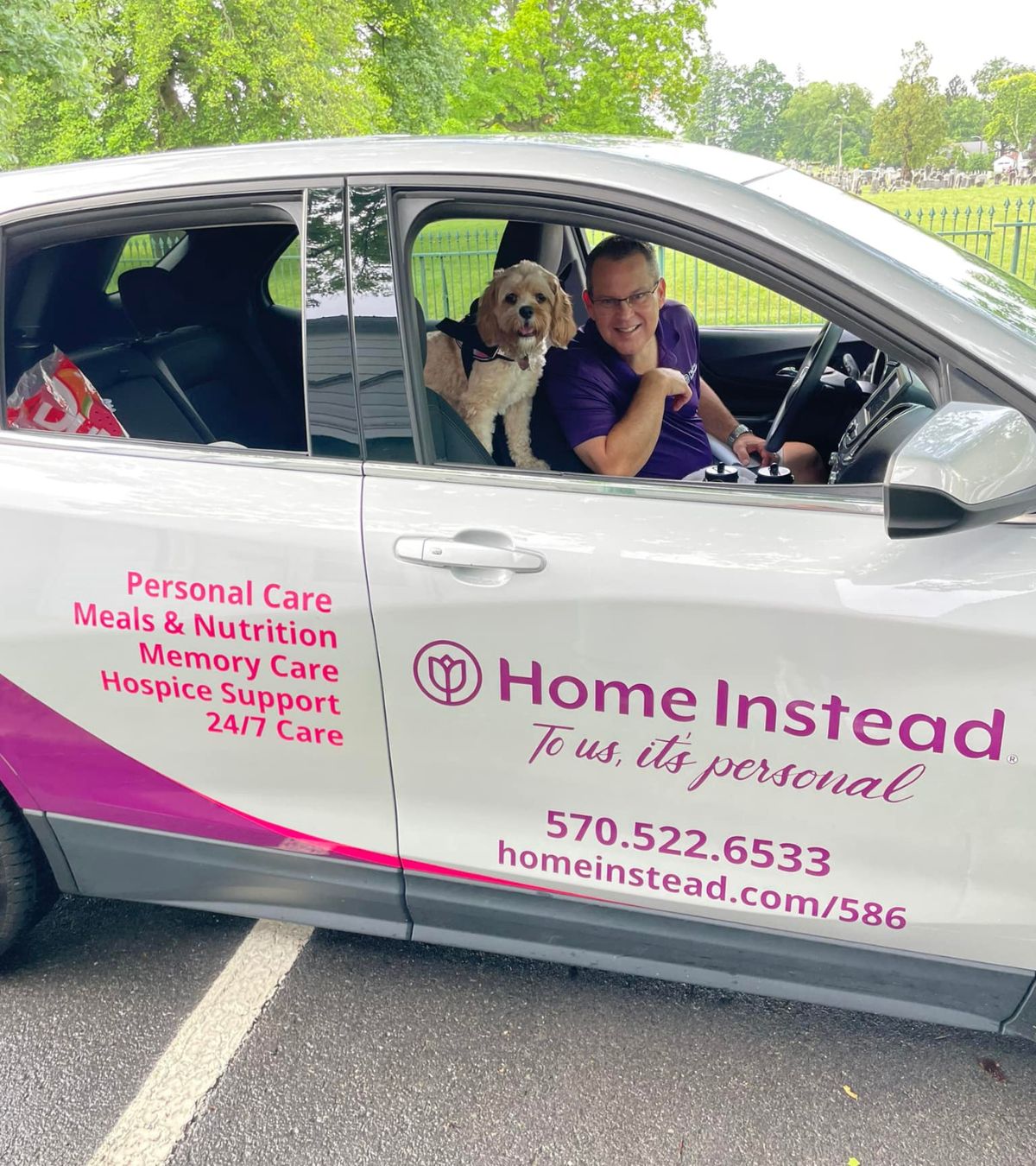 home instead owner and office mascot in wrapped car