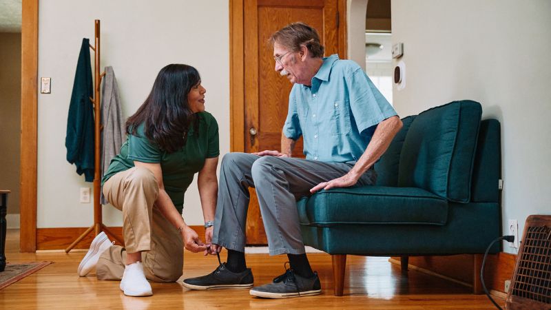 Home Instead caregiver helps senior client put on shoes in Villa Park, CA