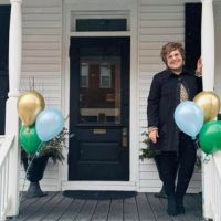 lady standing in front of the home instead building for grand opening
