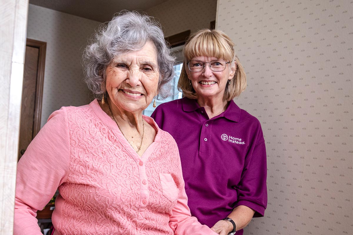Home-Instead-CAREGiver-Standing-with-Senior-Smiling