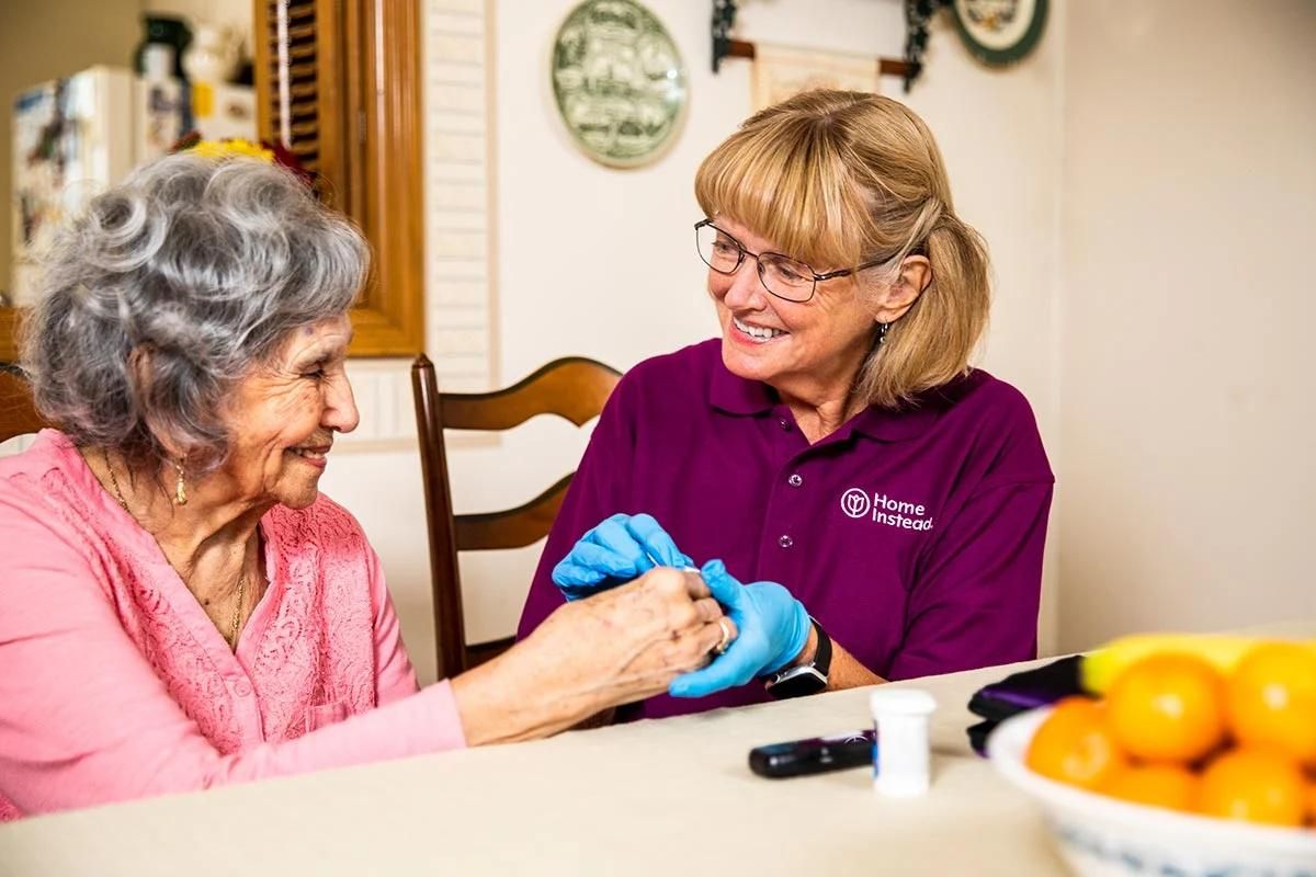 Home Instead caregiver giving senior medications