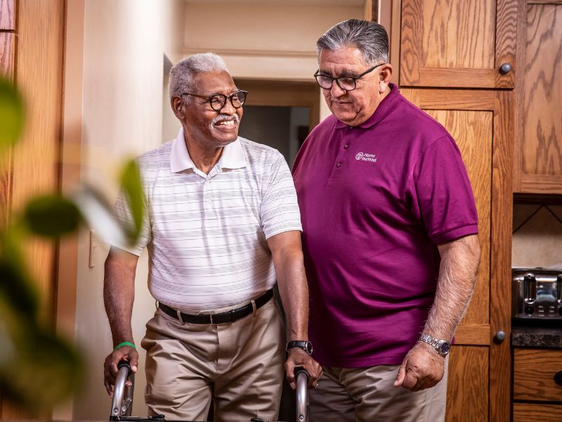 home instead caregiver assisting a senior on walker at home