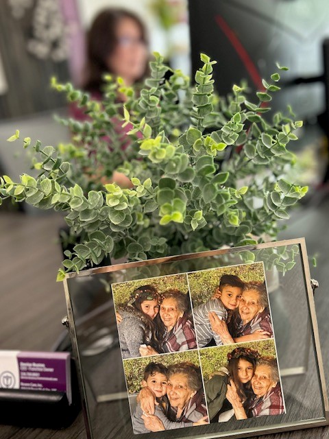 photo of owner Denise's grandmother with her grandchildren sitting on her desk with some greenery