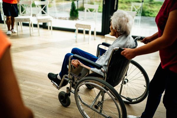 Senior Being Pushed in a Wheelchair by a Caregiver