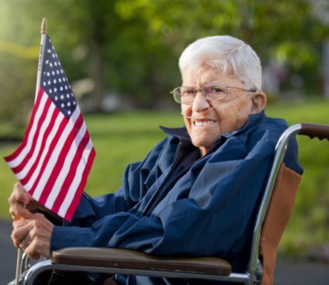 senior veteran in wheelchair holding USA flag