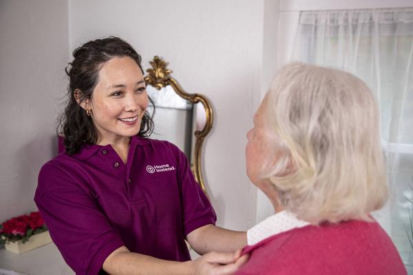 24 Hour Home Care Professional Helping Senior with Her Collar